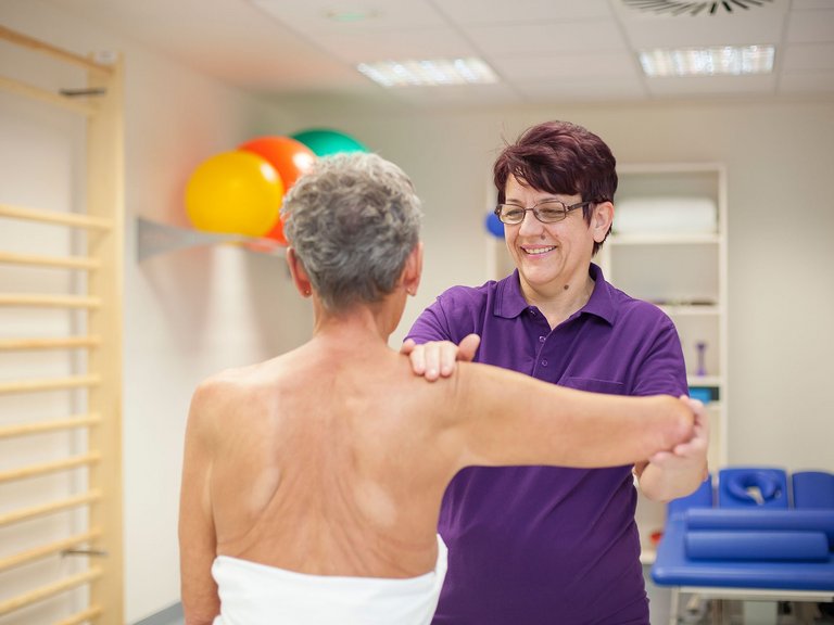Eine Physiotherapeutin der Wertachklinik macht Übungen am Arm einer Patientin