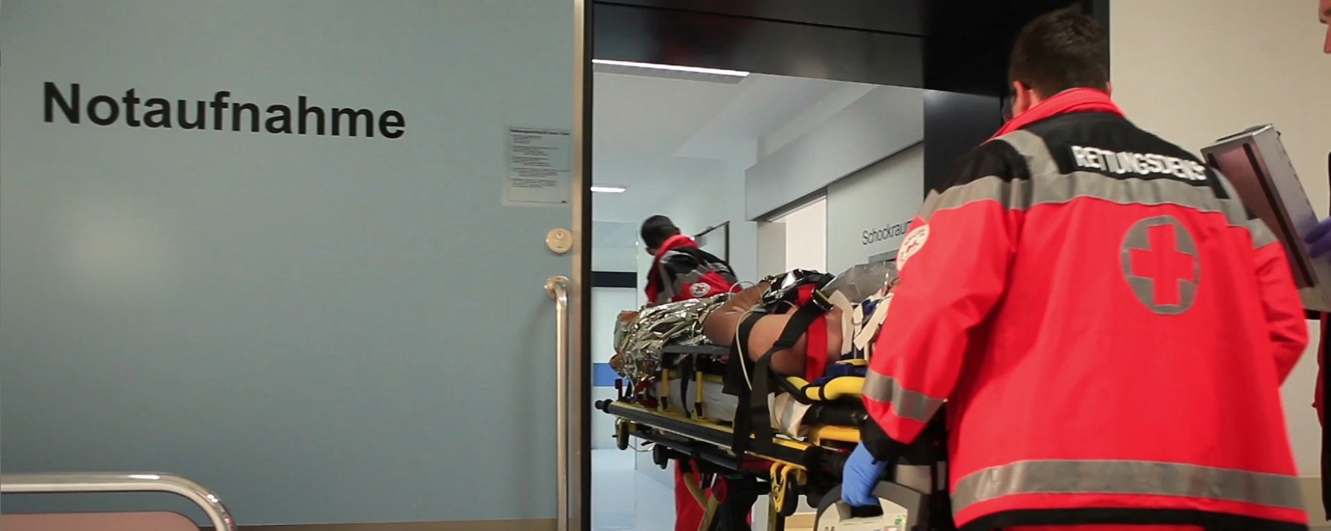 Rettungsdienst bringt einen Patienten auf einer Liege in die Notaufnahme